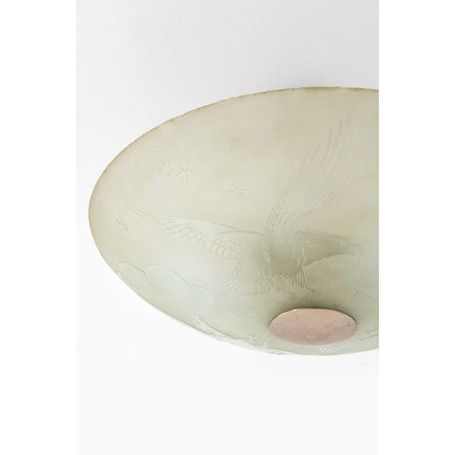 This rare Swedish ceiling lamp or flush mount, dating from the 1940s, is an evocative piece that combines narrative...