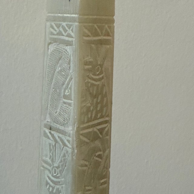 A vintage alabaster Egyptian obelisk featuring carved detailing and a classic tapered form. Measures approx: 2W x 2D x 17H...