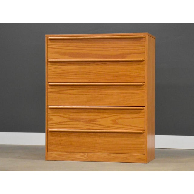A mid century modern style oak tall dresser with a plinth base. Unmarked. Excellent condition. Circa 1980’s. Made in USA....