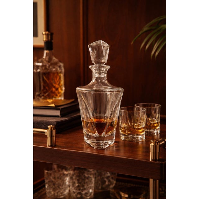 This elegant vintage crystal decanter features a striking geometric silhouette inspired by both Art Deco and Bohemian...
