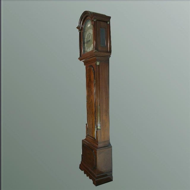 Mahogany case with a curved base. Applied moldings on the lower case with indented corners. Middle section with a hinged,...