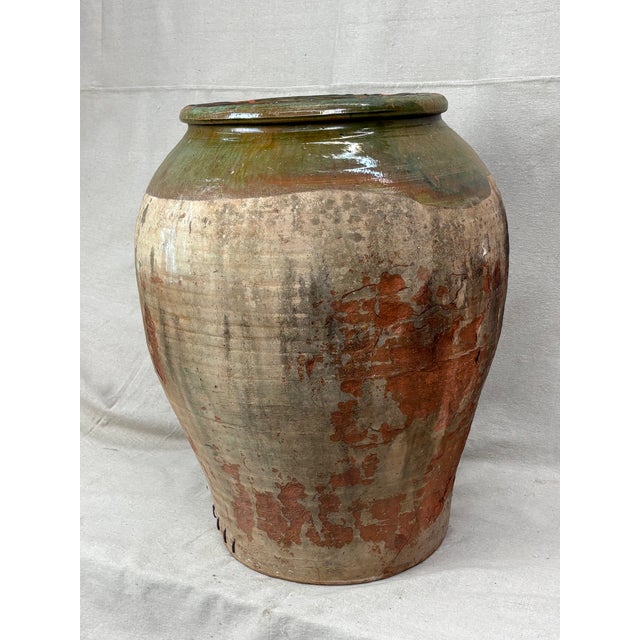 A striking, large earthenware storage jar, likely Mediterranean, dating to the late 19th or early 20th century. The vessel...