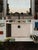 A stark kitchen sink takes center stage, surrounded by an array of everyday objects that evoke a sense of domesticity and...