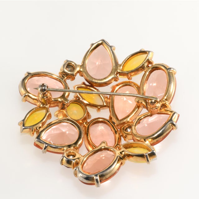 Gorgeous brooch featuring peachy pink unfoiled glass stones Schiaparelli collectors adore along with yellow accents....