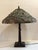 This 20th century Tiffany-style table lamp is a wonderful example of the Art Nouveau style. Accompanied by a beautiful...