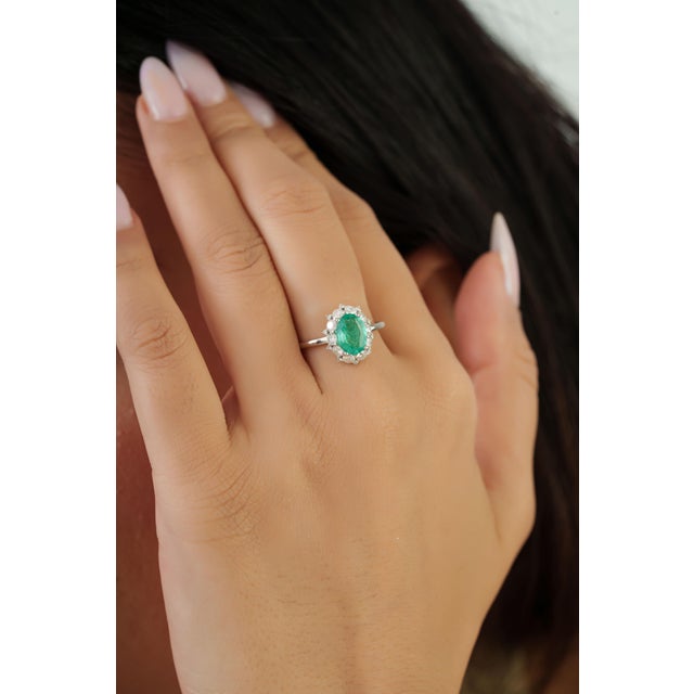 This cluster halo ring features a 0.86 carat oval-cut emerald set in 14k yellow gold. The emerald measuring 8 x 6 mm,...