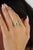 This cluster halo ring features a 0.86 carat oval-cut emerald set in 14k yellow gold. The emerald measuring 8 x 6 mm,...