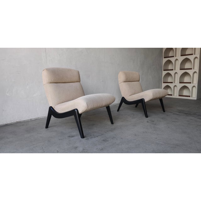 Rare and unique pair of Mid Century Scoop Chairs. This pair has the most beautiful sculpted wood bases that gently cradle...