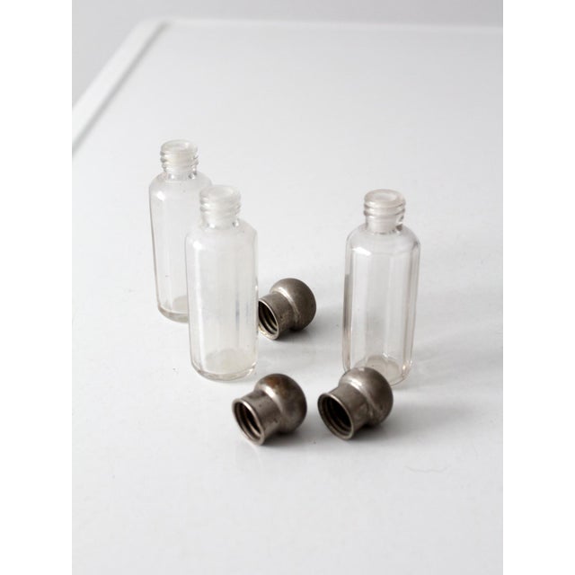 This set of three antique vanity bottles dates to the early 20th century and reflects the clean geometry of the Art Deco...