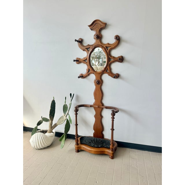 Gorgeous antique Victorian walnut hall tree with Medusa-like coat rack, and cast iron umbrella stand. Six coat or hat...