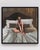 The artwork depicts a solitary figure sitting on a rumpled bed, bathed in warm, muted tones that evoke a sense of intimacy...