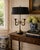 A classic bouillotte lamp rendered in warm brass, distinguished by its sculptural double horn base and clean, tailored...