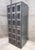 A six-compartment industrial steel locker unit with ventilated perforated doors and numbered brass plaques. A great pieces...