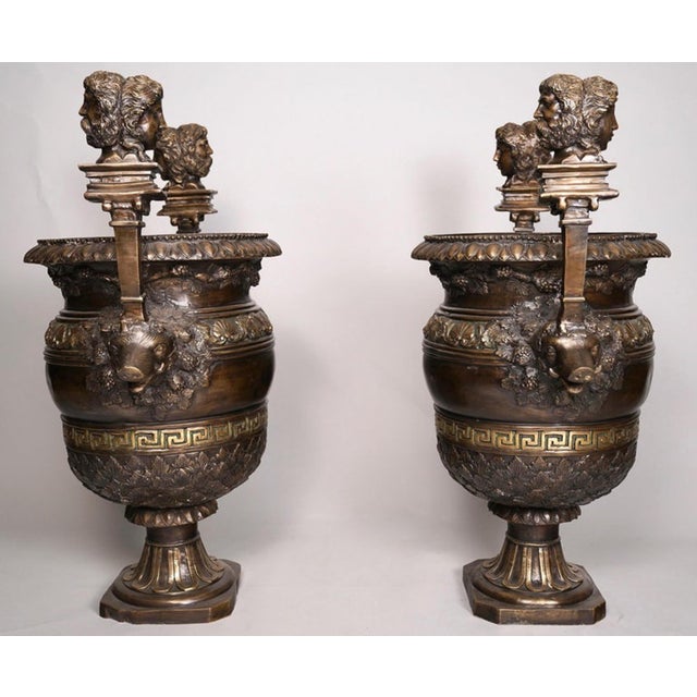 A Pair of Circa 1850 Pompeian Neoclassical Patinated Bronze Urns. These beautiful urns have boar's head handles surmounted...