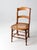 This is an antique American cane seat dining chair circa 1890s - 1920s. The French country style chair features a curving...