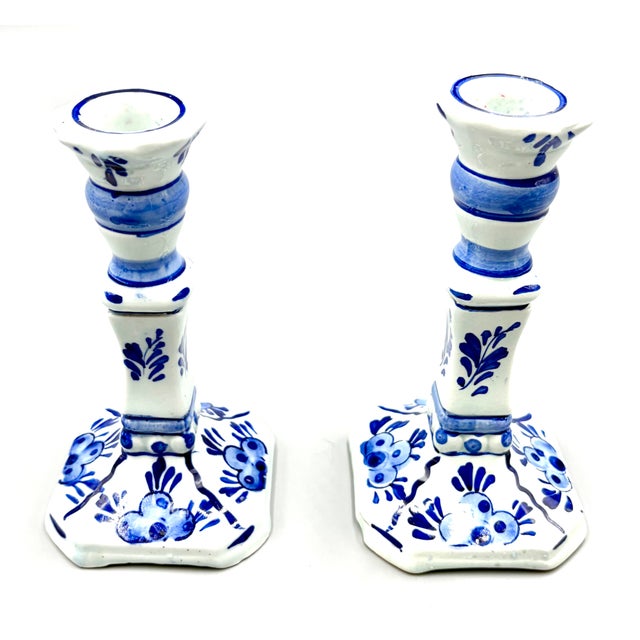 A lovely pair of Mid-Century Dutch Delft faience candlesticks. Maker's mark on reverse. These beautiful candlesticks are...