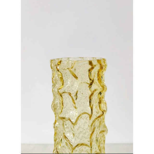 This striking vintage vase features a bold, textured bark-like surface in rich amber-colored pressed glass. The structure...
