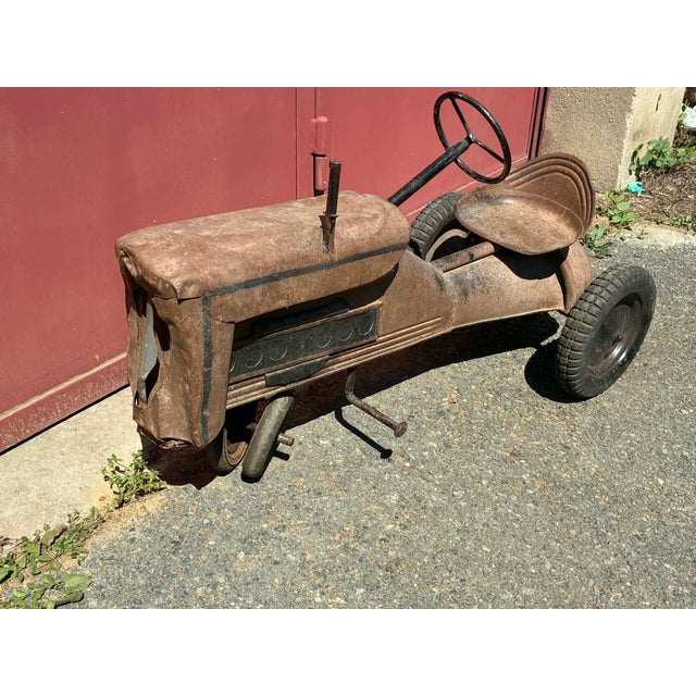 Charming vintage children's tractor, in original condition, all metal. It's fully functional and pedal-operated....