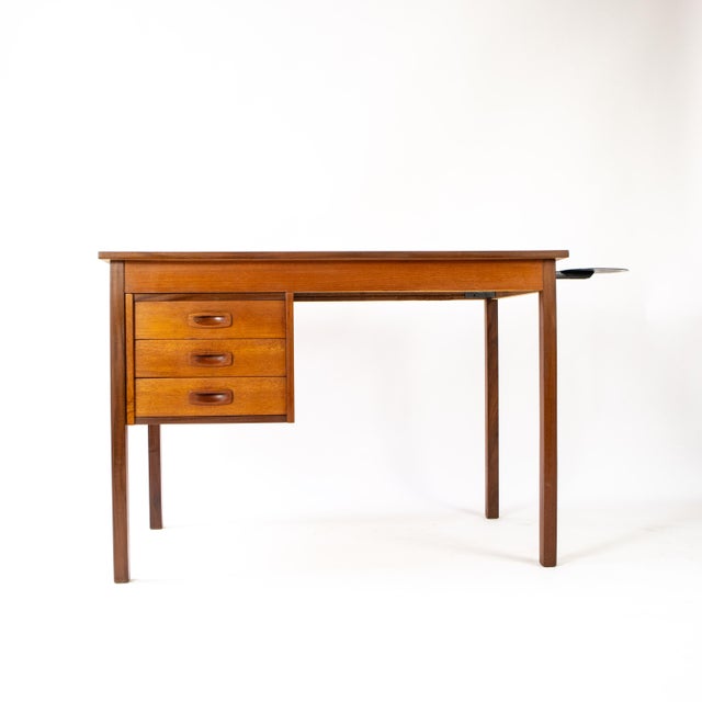 An elegant Danish teak desk from the 1960s with three practical drawers. A rare find with its original globe holder – an...