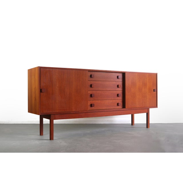 Gorgeous teak grain w/ two slider drawers to the right and left. 4 drawers providing ample storage. Iconic Domino Mobler...