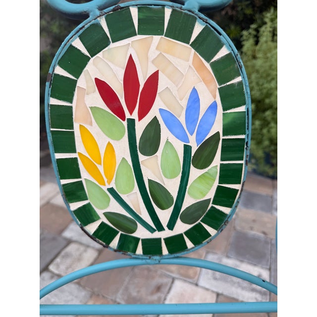 Charming vintage three-piece garden bistro set featuring two folding turquoise-painted iron chairs and a coordinating...
