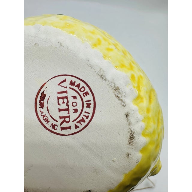 This is a charming ceramic lidded dish designed in the shape of a lemon. The vibrant yellow glaze with subtle speckling...