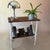 A charming vintage side table dating approximately to the 1950s, featuring an integrated lower book and magazine rack. The...