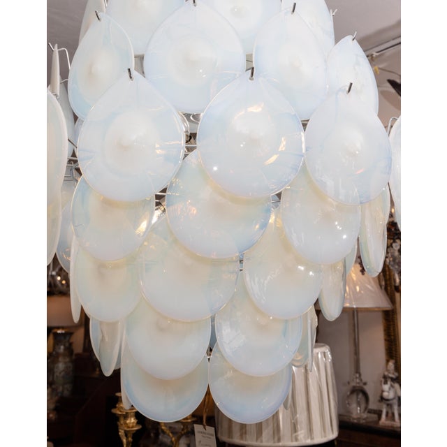 This is a unique mid-century Murano chandelier comprised of a cascade of circular translucent mouth-blown glass disks.