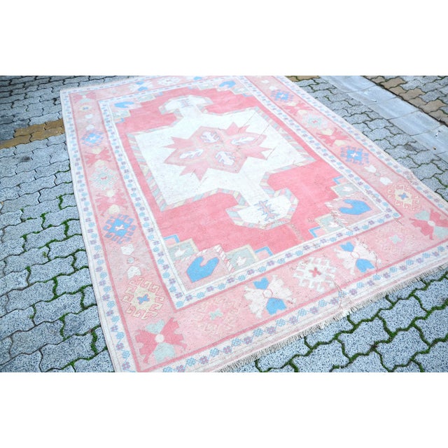 This is a vintage Turkish Oushak rug from the 1960s. The piece was hand-knotted.