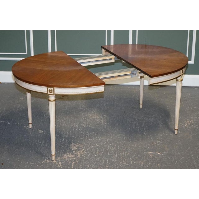 Kindel furniture cherrywood gold giltwood dining table. This table is vintage 1950s, an extendable table with three extra...