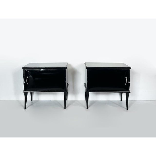 A pair of elegant and refined vintage bedside tables, characterized by clean, slender lines that recall mid-20th-century...
