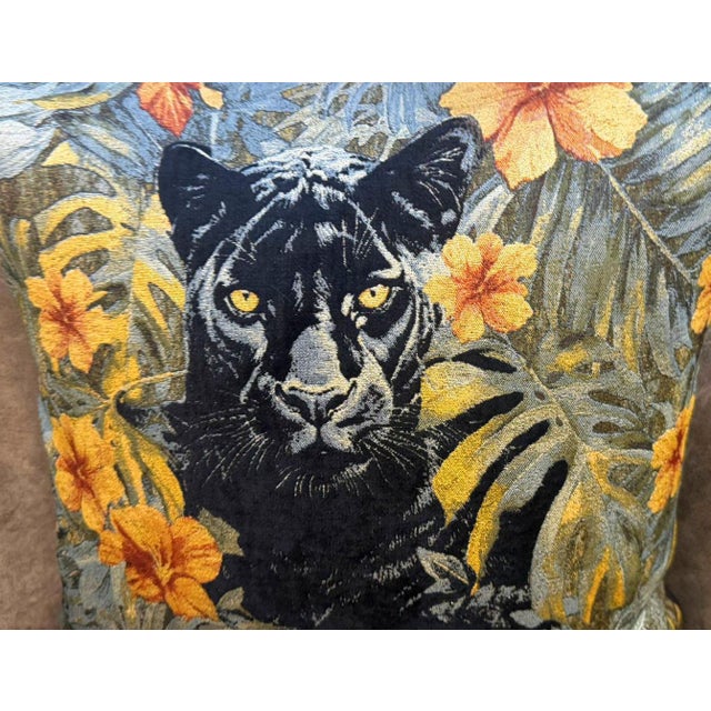A black panther portrait sits centered in a dense tropical field of monstera leaves and orange hibiscus flowers. The...
