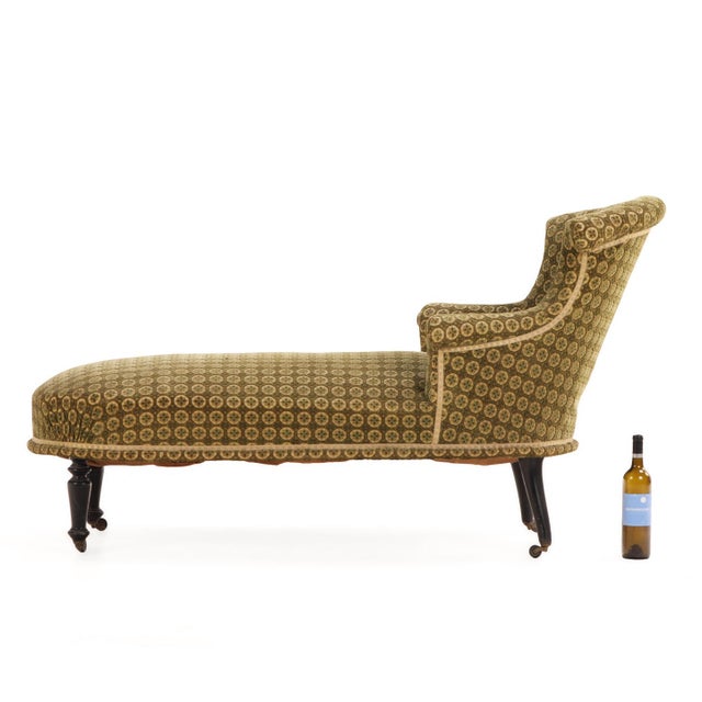 An elegant French Napoleon III chaise longue dating to circa 1860, featuring a graceful oval-back frame, scrolling crest...