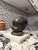 A substantial signed bronze infant bust mounted on a marble plinth. The sculpture features finely modeled facial details...