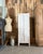 A charming parisian wardrobe. This small cabinet bears the marks of a long and well-lived life: cracked white and pale...