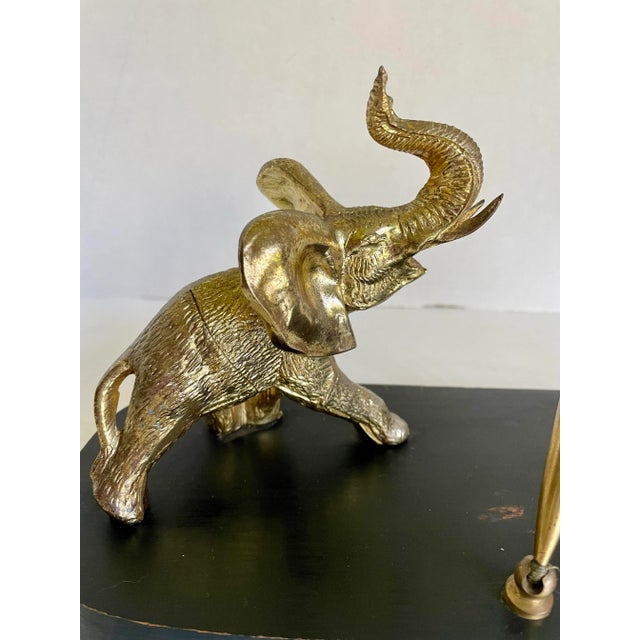 Here is a delightful organizing piece from the mid-century featuring a gold-finished metal elephant on a painted black...
