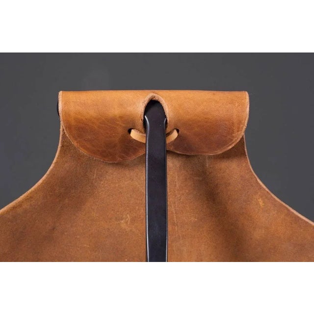 Lounge chair made of latigo leather on a black steel base. A very comfy and rich chair. This piece is attributed to the...