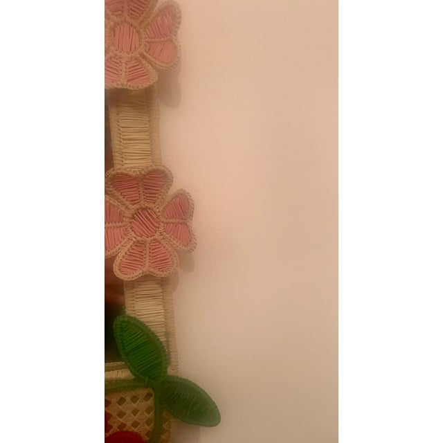 Whimsical flower and cherry mirror by Colombian designer Mercedes Salazar. Pink red green and neutral woven in Iraca palm....