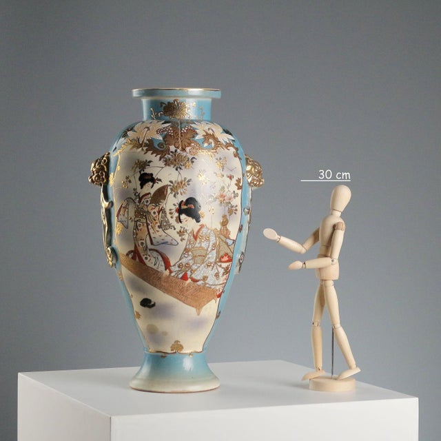Satsuma vase decorated with scenes of daily life in the reserve. Rich gold highlights and mask-shaped side handles. This...