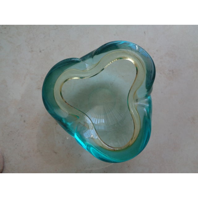 A substantial glass Mid-Century bowl that appears to be vintage Murano. It is a beautiful shade of blue with a very pale...