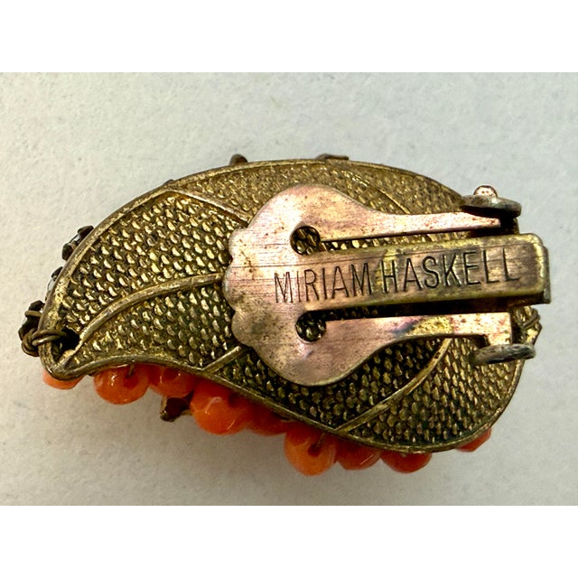 Miriam Haskell signed clip earrings with prong set rhinestones and wired coral glass beads. Frank Hess design. 1.25” x 0.75”