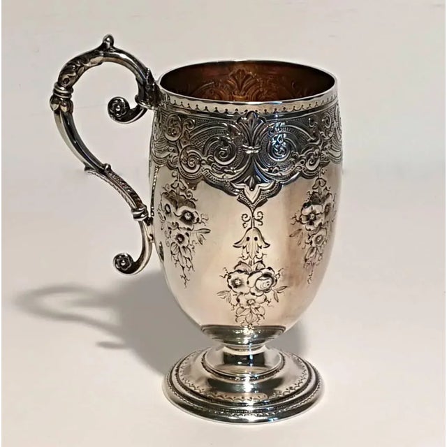 Silver embossed and chiselled glass with flower design and a wavy handle and golden interior. English manufacture town of...