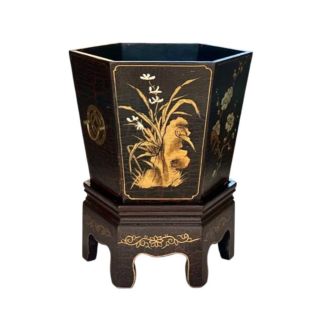 An octagonal wooden paint-decorated Chinoiserie jardiniere on pedestal featuring classic Chinese botanical motifs in gilt...