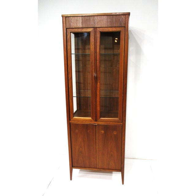 An exceptional oiled walnut tall curio display cabinet with double glass doors and glass surround, two adjustable glass...