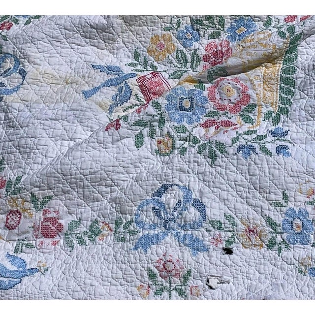 Beautiful quilt with crosstiched floral designs. There is a section with two holes that will need to be repaired. Very...