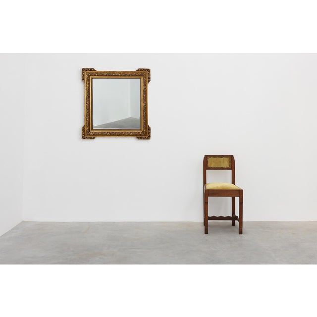 This large square giltwood mirror exemplifies the Baroque revival style of the 20th century, with its deeply carved...
