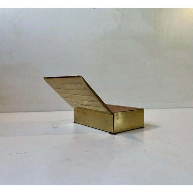 A brass cigarette or cigar box decorated horizontal ribbings/lines. It was made by an anonymous craftsman/designer in...