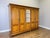 A substantial Vintage French wardrobe featuring five doors, a central mirrored panel and a warm Oak finish. The interior...