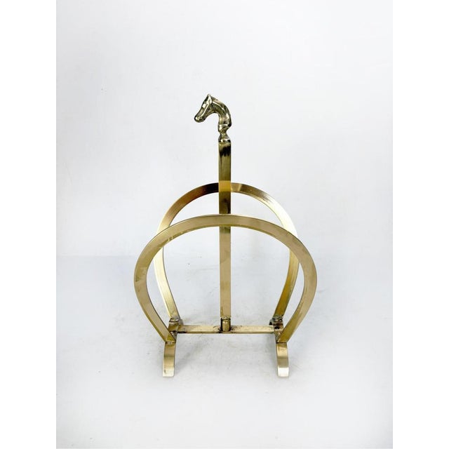 Brass magazine rack with an elegant, sculptural design typical of the 1970s. Its rounded arched structure gives it a...