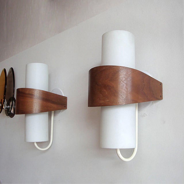 Elegant geometric sconces composed of opaque glass cylinders with a teak veneer wrap, wired for US standards, dimmable,...